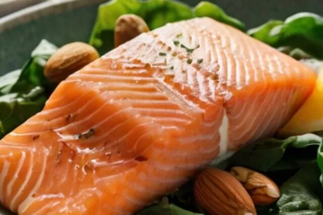 uma variedade de alimentos saudáveis, incluindo salmão, nozes, folhas verdes, frutas cítricas, ovos, iogurte e grãos integrais